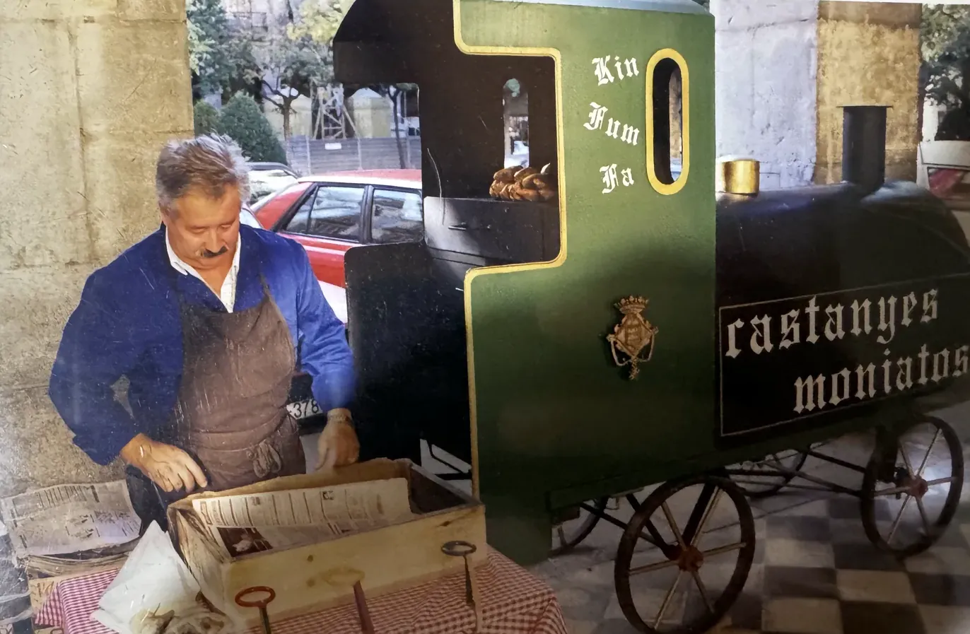 En Paco jove amb el davantal, preparant paperines al costat del trenet acabat d'estrenar